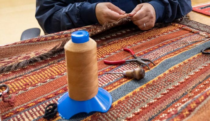 An expert patching a rug using tools